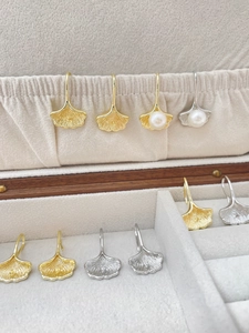Detail of 14k gold-filled ginkgo leaf earrings with pearls on velvet lining