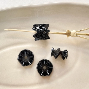 Macro-opname van golvende zwarte acryl kralen in keramiek voor DIY-sieraden