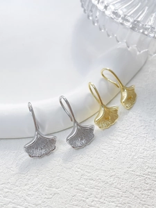 Detailed view of 14k gold plated ginkgo leaf ear hooks with natural veined texture