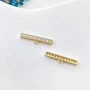 Détail d'un pendentif barre plaqué or 14k avec oxydes de zirconium et anneau de suspension