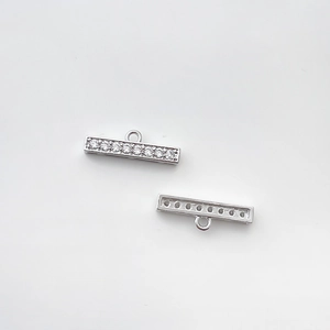 Détail de pendentifs barres argentés avec 7 oxydes de zirconium et anneaux centraux