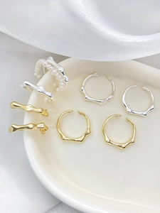 Detail von 14k Gold und Silber plattierten Bambusringen mit flüssiger Metalltextur auf Keramik