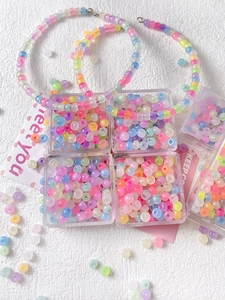 Macro shot of colorful matte macaron resin beads in a transparent box for DIY jewelry making