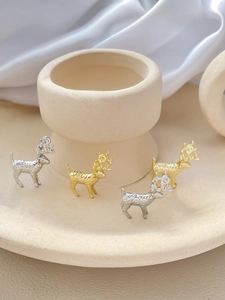 Dettaglio macro di ciondoli a cervo strutturati in oro 14k e argento per gioielli