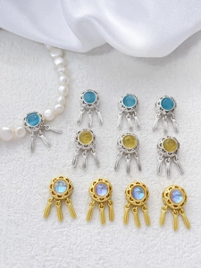 Detailed view of dreamcatcher charms with colorful gemstones and hanging metal feathers