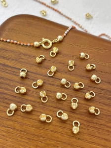 Detailed macro view of 14k gold-plated jewelry clasps and end beads for DIY necklaces