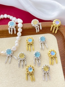 Detail of dreamcatcher pendant charms with feathers and gemstones on soft velvet