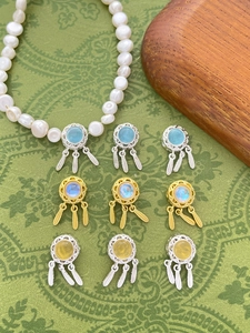 Macro shot of silver and gold plated dreamcatcher pendants with opal and feathers