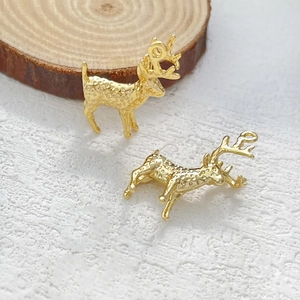 Dettaglio macro di ciondoli a forma di renna 3D placcati in oro 14k per gioielli
