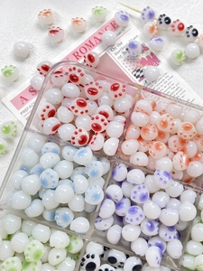 Close-up of colorful resin cat paw beads for DIY jewelry making in a storage box