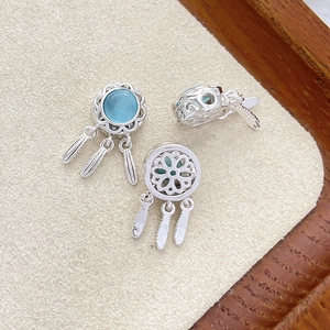 Detailed view of silver dreamcatcher charms with blue opal and feather pendants for jewelry