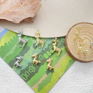 Ciondoli a cervo e cerbiatto placcati oro 14k per gioielli fai da te su sfondo di legno