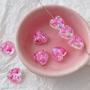 Detail view of heart-shaped DIY resin beads with pink interior patterns and white dots