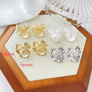 Detail van 14k gouden strik pareloorbellen met afmetingen 16mm bij 18mm op display