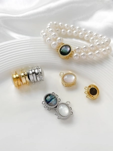 Macro view of gold and silver magnetic jewelry clasps with inlaid mother of pearl shells