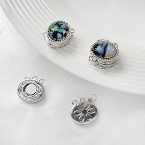 Macro detail of multi-strand silver magnetic jewelry clasp with abalone shell inlay