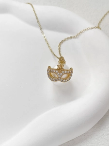 Dettaglio collana con pendente a perla, maschera dorata e zirconi incastonati