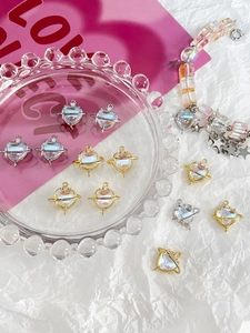 Macro shot of heart-shaped moonstone planet charms for DIY jewelry making in gold and silver