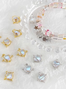 Close-up of heart-shaped Saturn moonstone charms in gold and silver for jewelry making