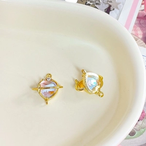 Macro detail of heart moonstone planet pendant with gold finish on ceramic tray