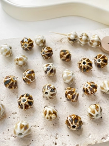 Macro shot of brown leopard print ceramic lantern beads for DIY jewelry making
