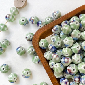 Macro shot of kiln-fired glazed ceramic pumpkin beads for DIY handmade jewelry crafting