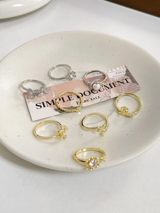 Nahaufnahme von gemischten gold- und silberfarbenen Ringen mit Perlen und Sternen