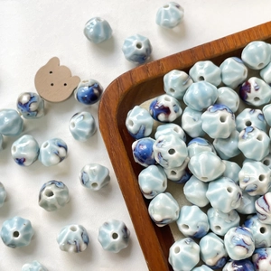Macro shot of light blue ceramic lantern beads with vintage glaze for DIY jewelry