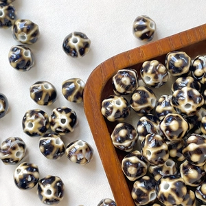 Macro detail of ceramic pumpkin beads with leopard pattern for DIY jewelry making