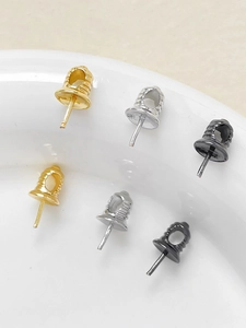 Dettaglio macro di ciondoli a campana placcati oro 18k nei colori oro argento e nero