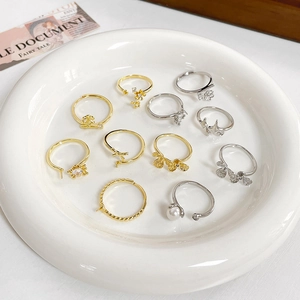 Verstellbare gold und silber plattierte Ringe mit Blumen- und Sterncharms in Keramikschale