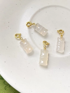 Dettaglio di quattro ciondoli in agata rosa a forma di bambù con chiusure a molla in oro 18K