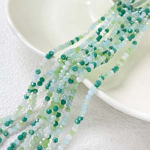 Gros plan de perles en verre facettées de 2-3 mm en vert et blanc pour bijoux DIY