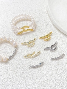 Macro view of gold-plated liquid lava metal connectors paired with elegant white pearls