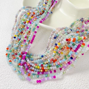 Perles en verre facetté colorées pour la création de bijoux sur plateau en céramique