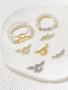 Detailed view of gold and silver lava-style metal connectors with pearl bracelets