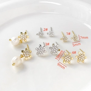 Macro shot of gold and silver snowflake earrings with sparkling cubic zirconia in four sizes