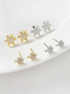 Macro shot of gold and silver snowflake zircon studs for DIY handmade jewelry components