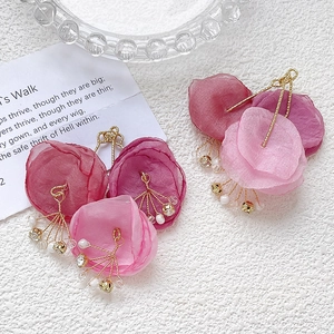 Detail view of 3D layered mesh flower pendant with crystal beads and gold mini bell charm