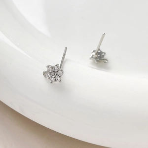 Macro shot of gold-plated snowflake stud earrings with sparkling zircon inlay details