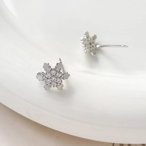 Macro detail of snowflake stud earrings with silver plating and sparkling cubic zirconia