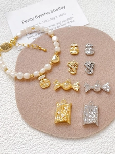 Detail of 18k gold plated dragon and candy charms with freshwater pearl bracelet
