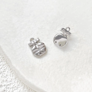 Macro shot of silver-colored ladybug pendants with white zircon stones and polished back