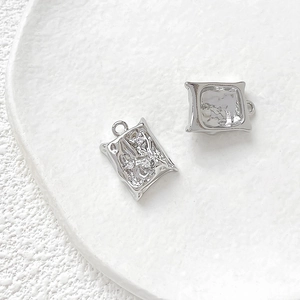 Close-up of irregular textured silver pendants with lava pattern and top metal rings