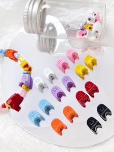 Colorful macaron smiley face acrylic beads for DIY jewelry making displayed on a mirror