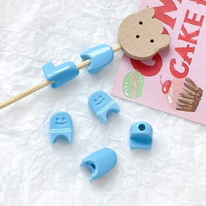 Macro shot of light blue smiley face beads for DIY jewelry and handmade accessories