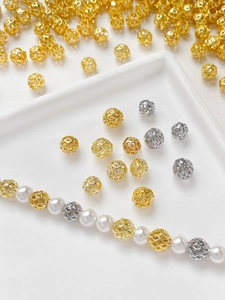 Macro shot of 14k gold-plated hollow mesh beads and pearls for DIY jewelry making