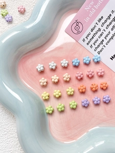 Macro shot of colorful flower-shaped resin beads for DIY jewelry making in a tray