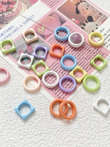 Macro shot of macaron-colored acrylic flower beads in round and square shapes for DIY jewelry