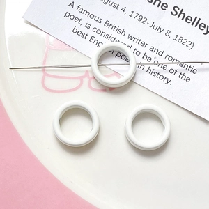 Close-up of three mini white macaron floral beads for DIY jewelry making accessories